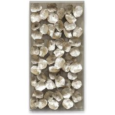 a white wall with some silver rocks on the bottom and one is in front of it