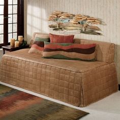 a living room with a couch, rugs and wall hangings on the wall