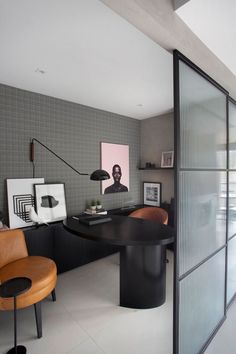 an office with a black table and brown chairs in front of a glass door that leads to another room