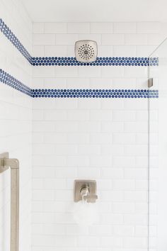 a shower with blue and white tiles on the walls