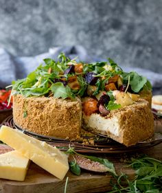 a close up of a cake on a plate with cheese and other food items around it