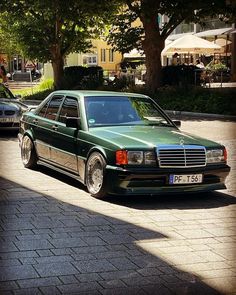 a green car parked on the side of a road