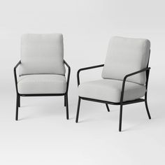 two chairs sitting next to each other on a white surface with one chair facing the other