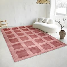 a living room with a couch, chair and rug in the middle on the floor