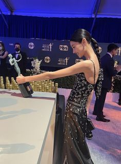 a woman in a black and white dress holding an award