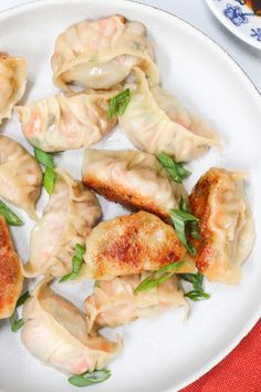 some dumplings are sitting on a white plate