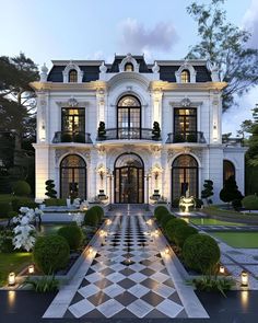 a large white building with lots of windows and lights on it's front entrance