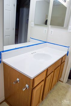 a bathroom counter with blue tape on it