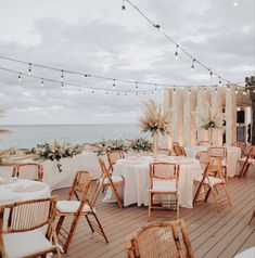 tables and chairs are set up on the deck for an outdoor wedding reception by the ocean