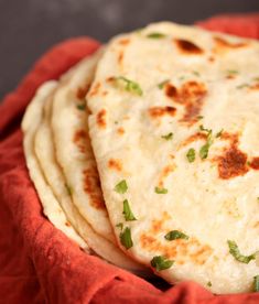 three flat breads sitting on top of a red cloth