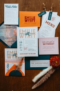 the wedding stationery is laid out on top of each other, including an orange flower