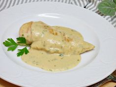 a white plate topped with meat covered in gravy