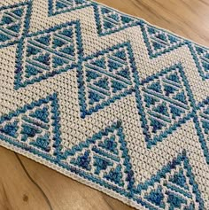 a blue and white rug sitting on top of a wooden floor next to a wood floor