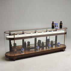 a display case with several bottles on the top and below it, in front of a gray background