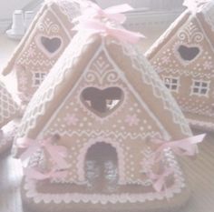 three decorative gingerbread houses with pink bows