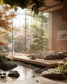 a bed sitting in the middle of a room next to a pond with rocks on it