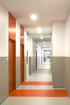 an empty hallway with orange and white stripes on the floor