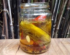 a jar filled with pickles sitting on top of a wooden table