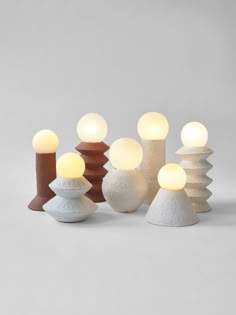 several different types of lights sitting next to each other on a white surface with grey background