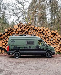 a van parked in front of a pile of logs