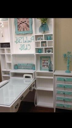 a white desk topped with lots of drawers next to a shelf filled with books and other items