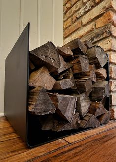 a stack of wood sitting on top of a wooden floor next to a brick wall