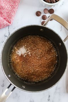 a pan filled with food sitting on top of a counter next to a bowl and spoon