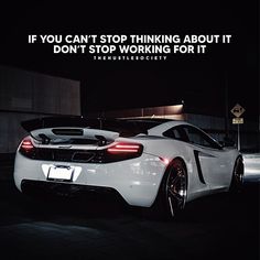 a white sports car parked in front of a building with a quote above it that reads if you can't stop thinking about it, don't stop working for it