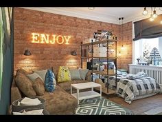 a living room filled with lots of furniture next to a wall mounted brick sign that says enjoy