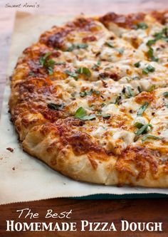 a pizza sitting on top of a piece of parchment paper next to a wooden table