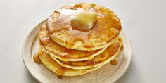 a stack of pancakes covered in syrup and butter