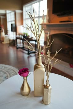 two vases with flowers are sitting on a table in front of a fire place