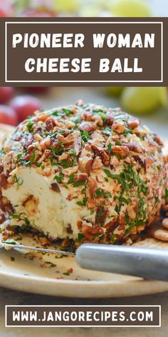 a cheese ball on a plate with grapes and nuts