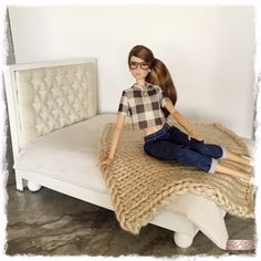 a doll sitting on top of a white bed