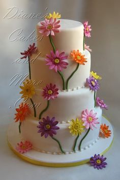 a three tiered cake decorated with colorful flowers