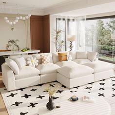 a living room with white couches and black and white rugs on the floor