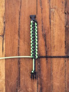 a wooden floor with a green and black cord attached to the end of a piece of wood