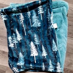 two blankets with trees on them sitting on the floor