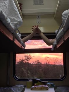 two people holding hands while sitting on a train