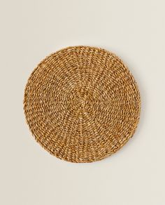 a round woven placemat on a white surface