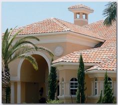 a large house with palm trees in front of it and a clock on the roof