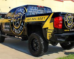 a black and yellow truck parked in front of a building