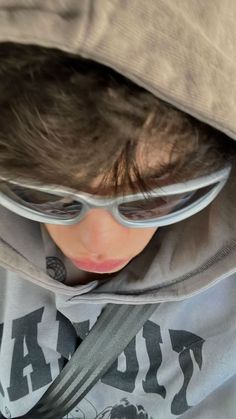 a young boy wearing goggles and a hoodie with his head under the hood