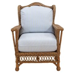 a wicker chair with blue and white striped cushions on it's back end