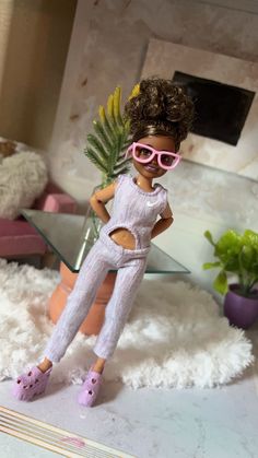 a doll with pink sunglasses and sandals standing in front of a mirror on a white rug