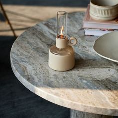 a small table with a candle on it and some plates in the backround