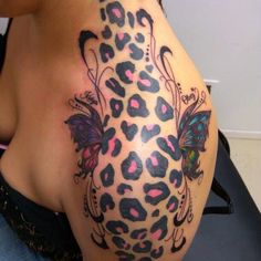 a woman with a tattoo on her back has a butterfly and leopard print on it