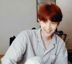 a man with red hair is smiling at the camera