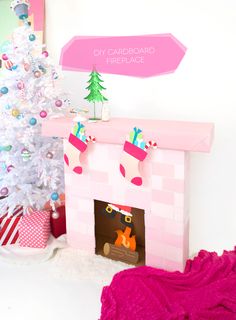 a pink fireplace with presents on it and a christmas tree in the corner next to it