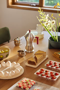 the table is set up with desserts and other items on it, including strawberries